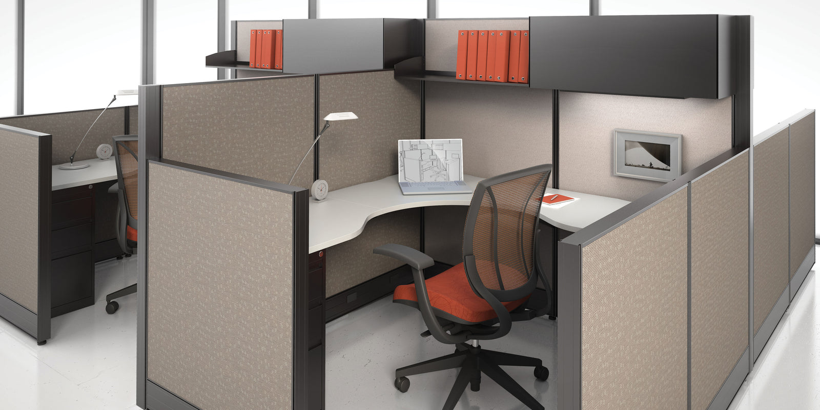 Modern office cubicle with desk, chair, and office supplies in a bright room.