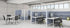 Modern office setup with desks, chairs, and partition walls.