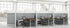 Modern office with cubicles and desks in a bright room with large windows.