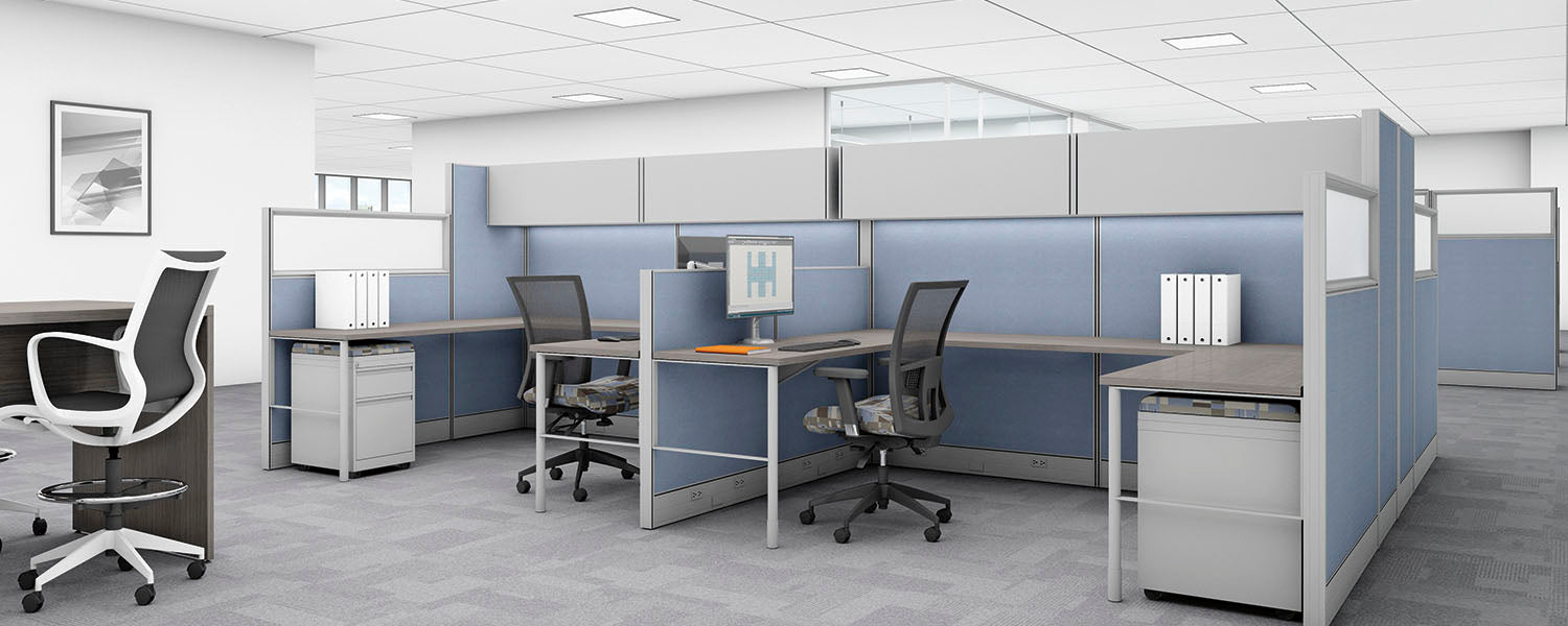 Modern office cubicle setup with desks, chairs, and office supplies.