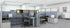 Modern office layout with desks and partitions in a well-lit room.